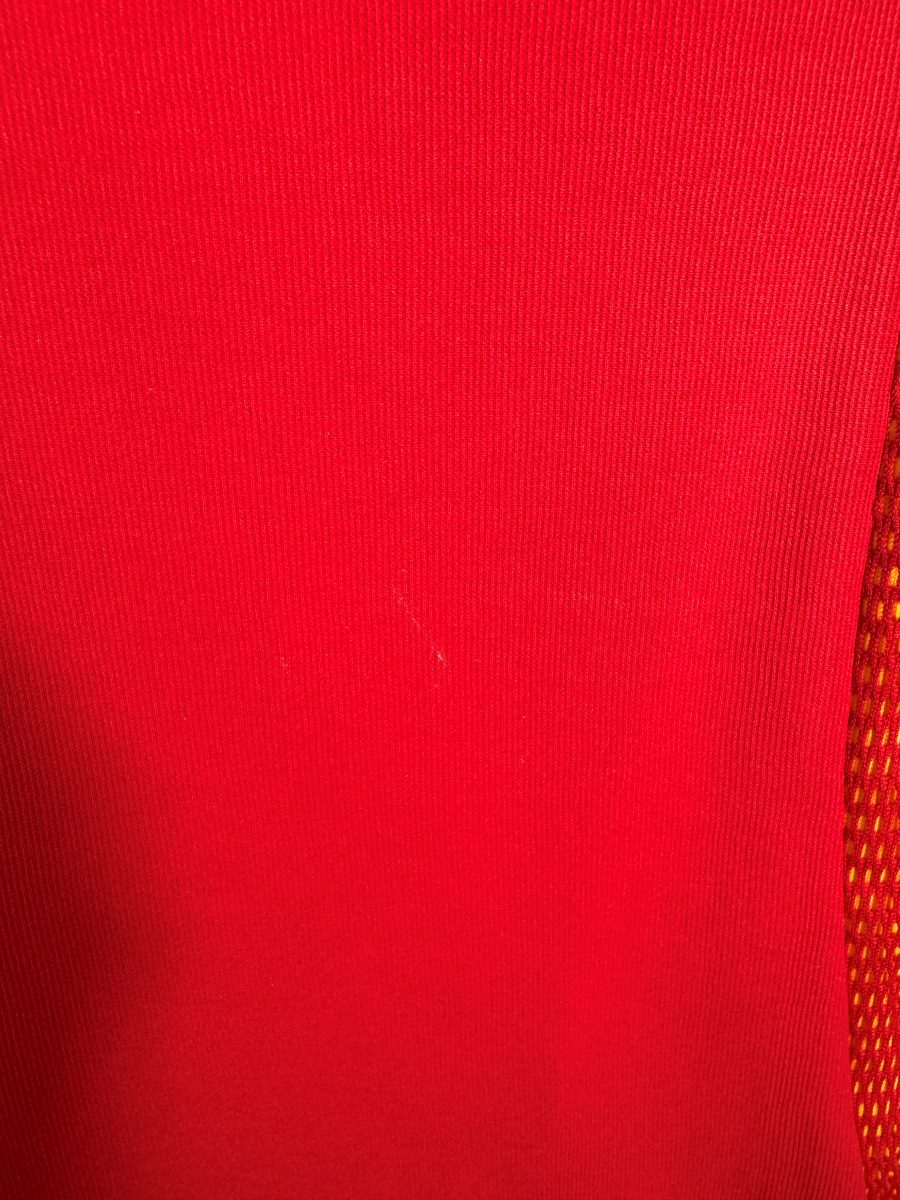 Petit fil tiré sur le tissu rouge du maillot Espagne domicile 2002