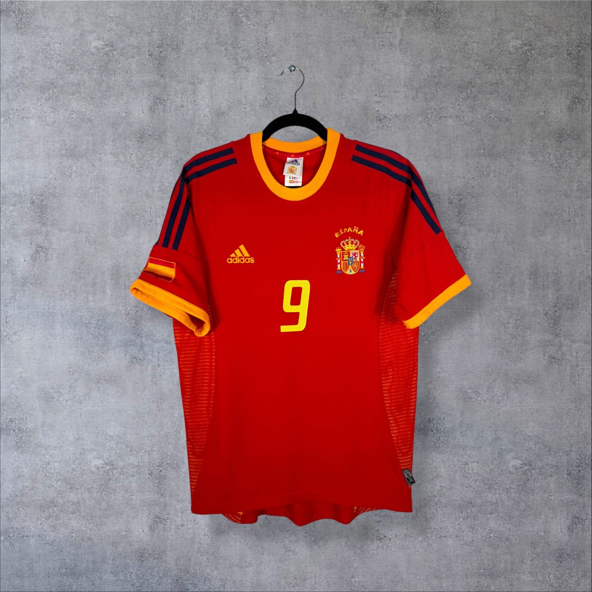Maillot Espagne 2002 domicile rouge de face, col jaune, trois bandes bleu marine sur les épaules, numéro 9 sur la poitrine