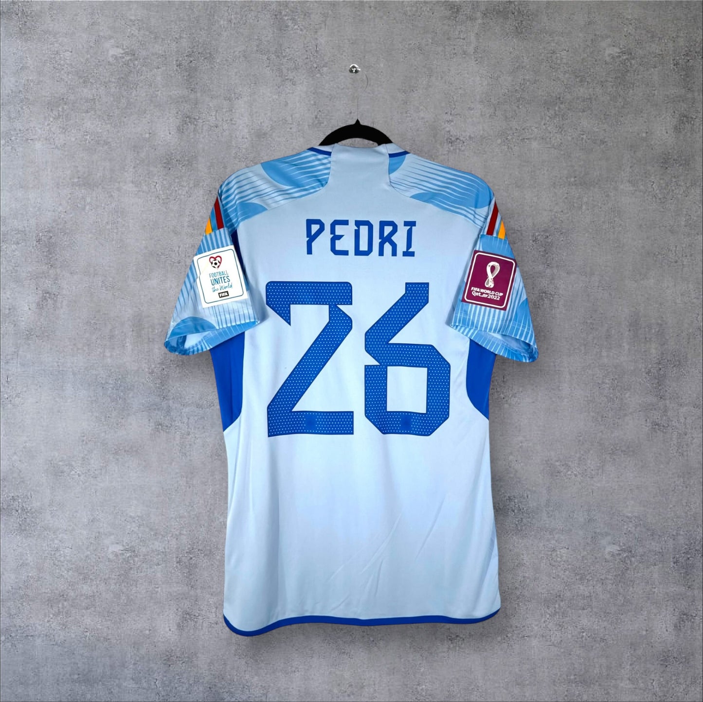 Dos du maillot Espagne Extérieur 2022 bleu ciel avec flocage bleu PEDRI 26 et patchs Coupe du Monde.