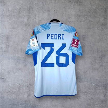 Dos du maillot Espagne Extérieur 2022 bleu ciel avec flocage bleu PEDRI 26 et patchs Coupe du Monde.
