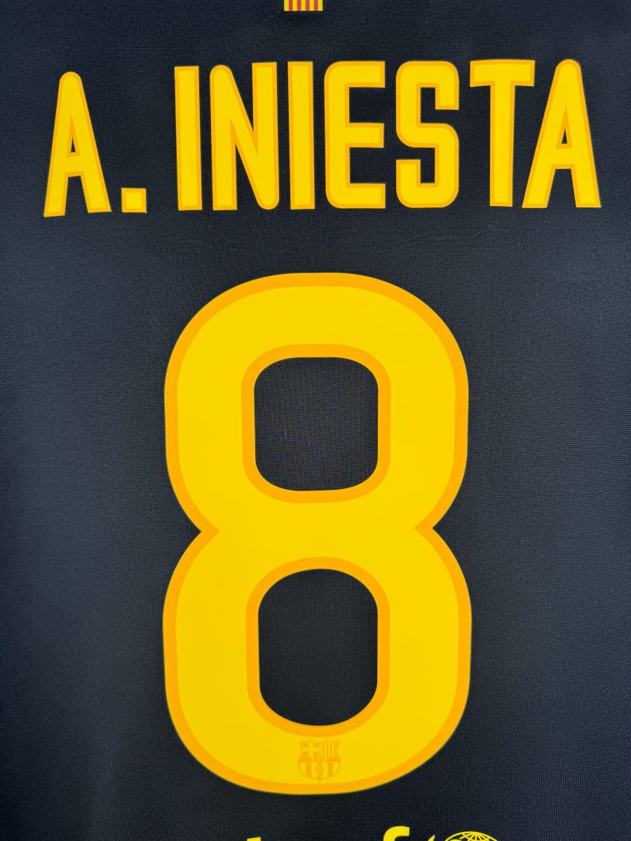 Détail du flocage jaune A. Iniesta 8 avec mini-écusson dans le numéro, maillot FC Barcelone extérieur 2011-2012