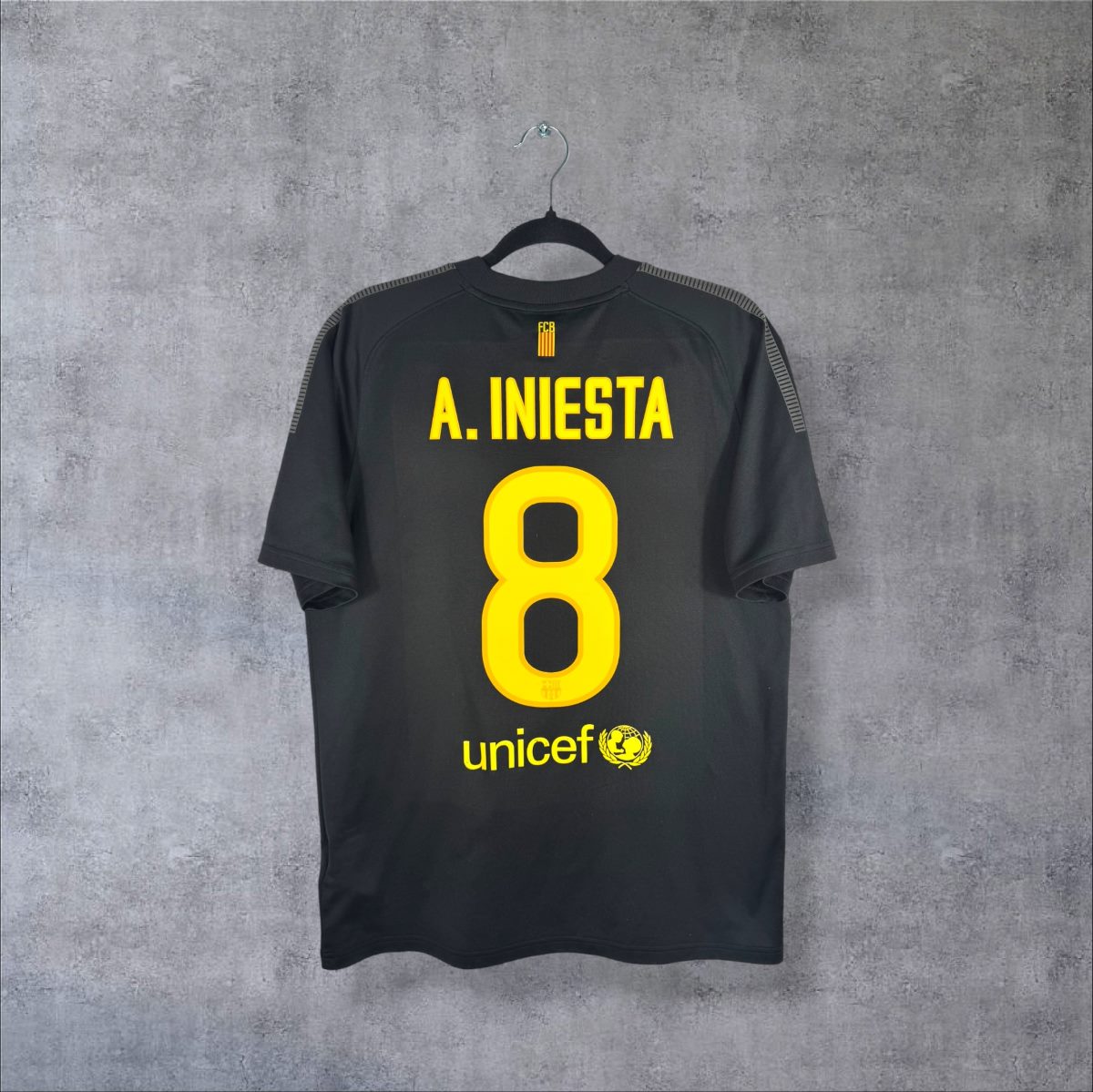 Dos du maillot extérieur noir du FC Barcelone 2011-2012 Nike, flocage jaune A. Iniesta 8 et sponsor Unicef