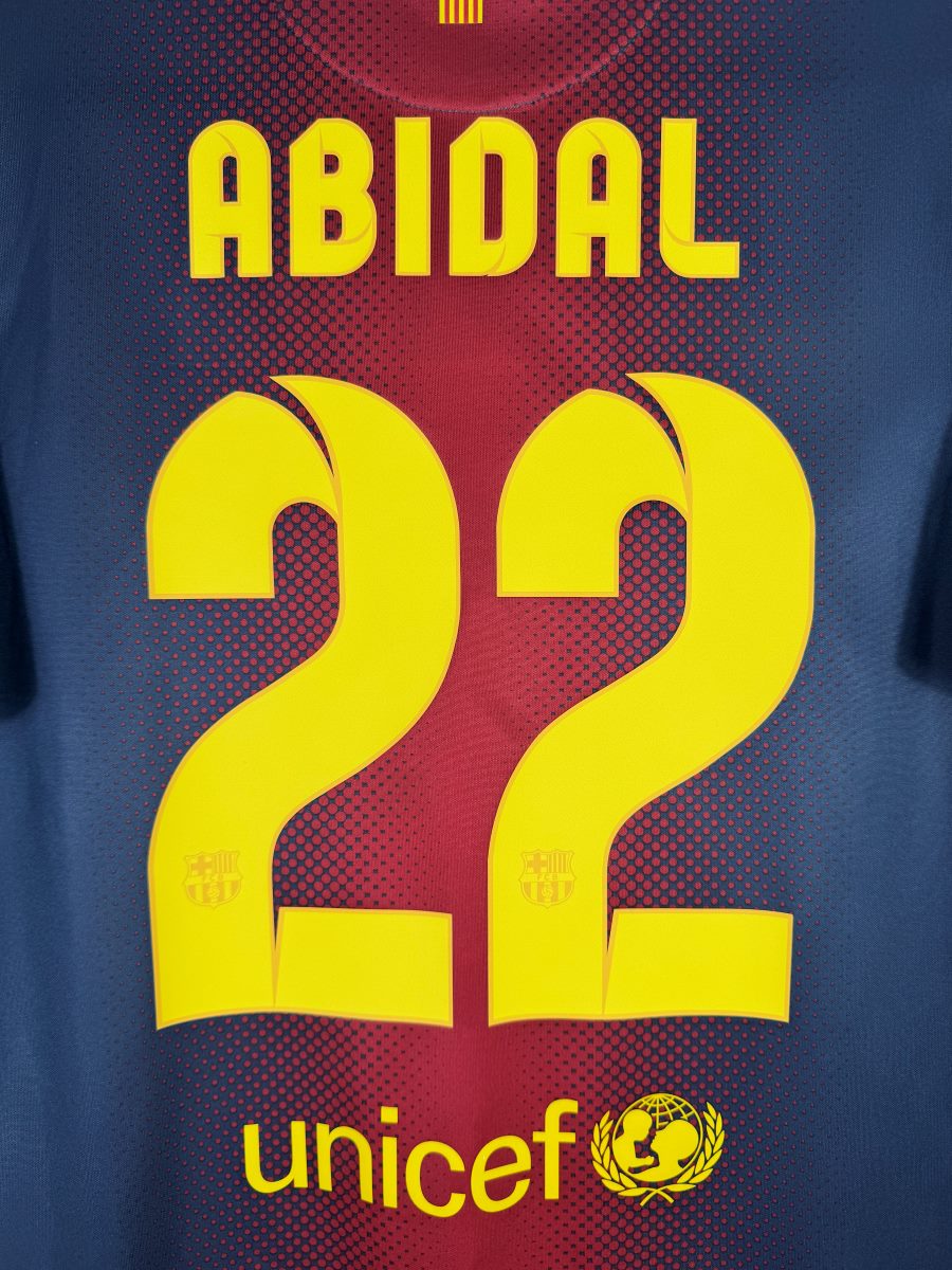 Gros plan du flocage Abidal N°22 jaune avec écussons FCB intégrés, maillot Barcelone 2012-2013
