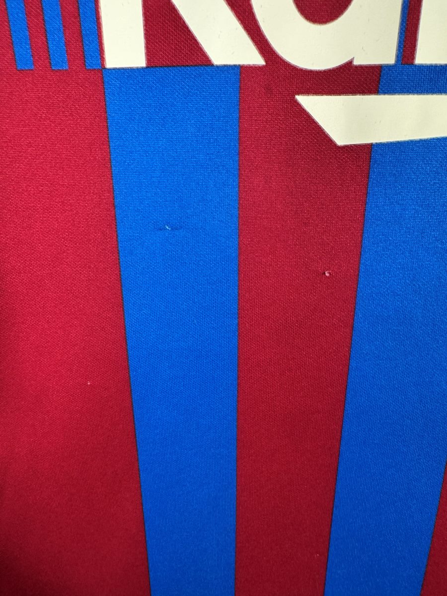 Défaut du maillot FC Barcelone 2021-2022 : micro-bouloches et petits points clairs sur l'avant, sous le sponsor Rakuten