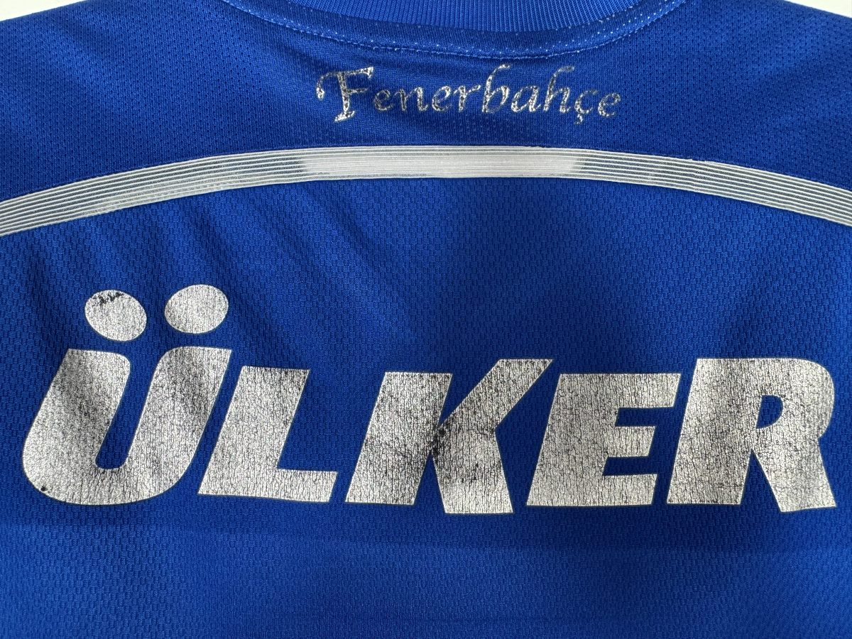 Défaut : sponsor Ülker argenté craquelé au dos du maillot Fenerbahçe 2014-2015