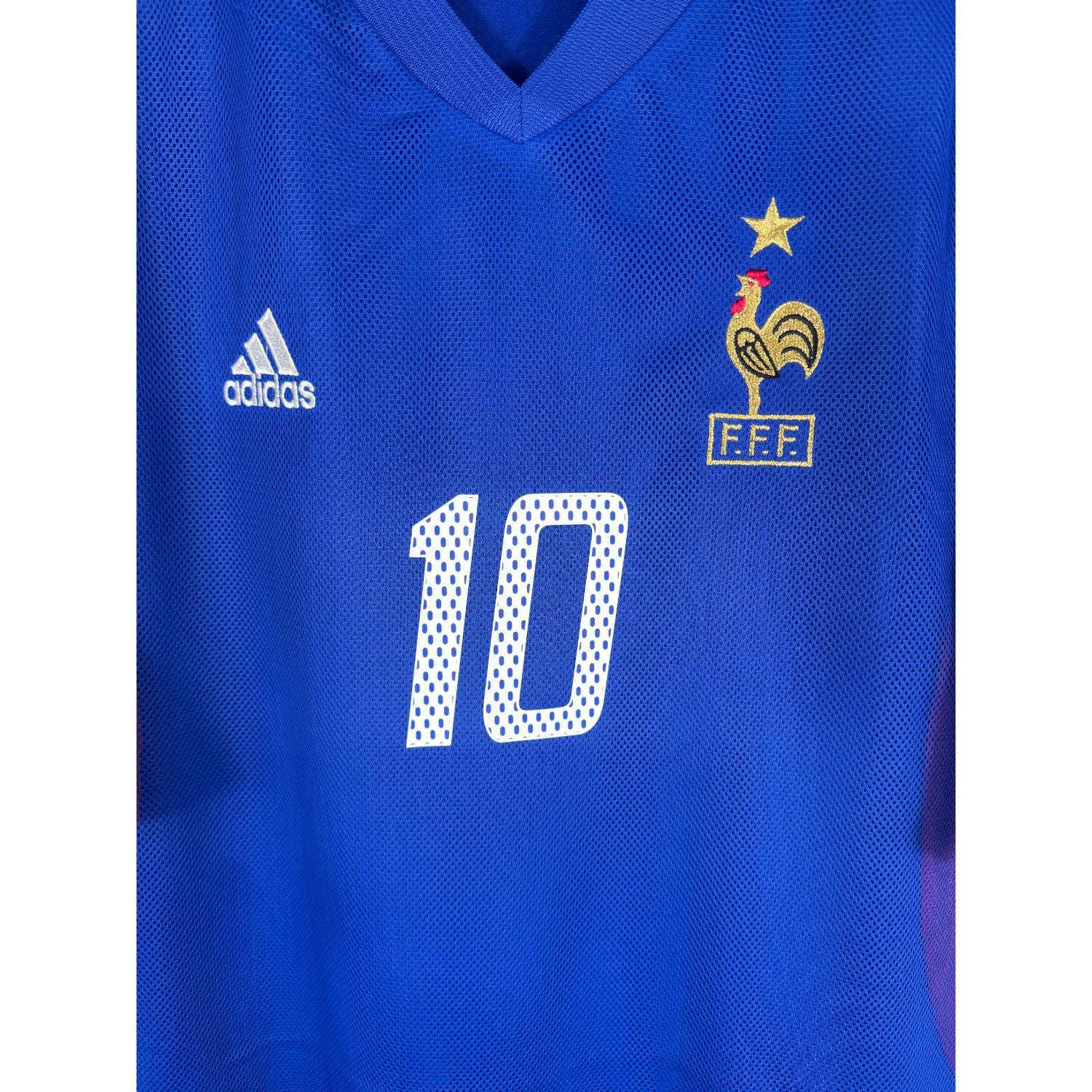 Détail de l'écusson de la France avec une étoile et du logo Adidas