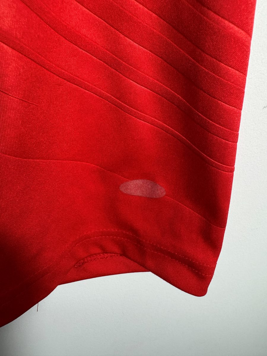 Trace claire d'une petite étiquette décollée en bas du maillot France extérieur 2008