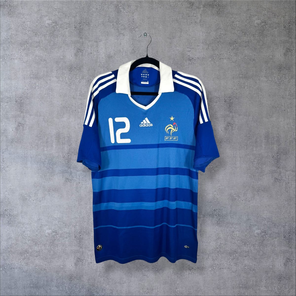 Maillot France 2009 domicile de face, rayures horizontales bleues, col polo blanc, numéro 12 sur la poitrine