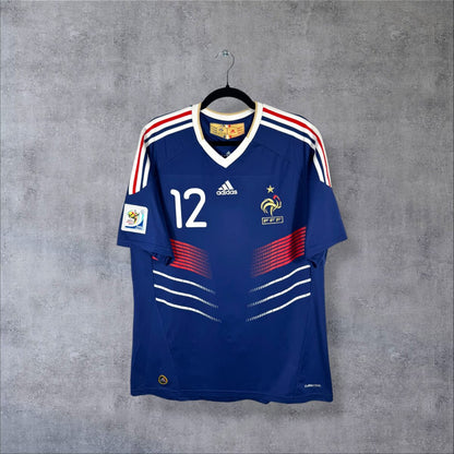 Maillot France domicile 2010 adidas de face, col en V blanc, chevrons tricolores, numéro 12 Henry
