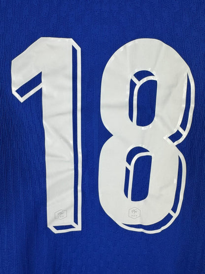 Gros plan du numéro 18 du maillot France 2024 avec les écussons hexagonaux FFF intégrés dans les chiffres