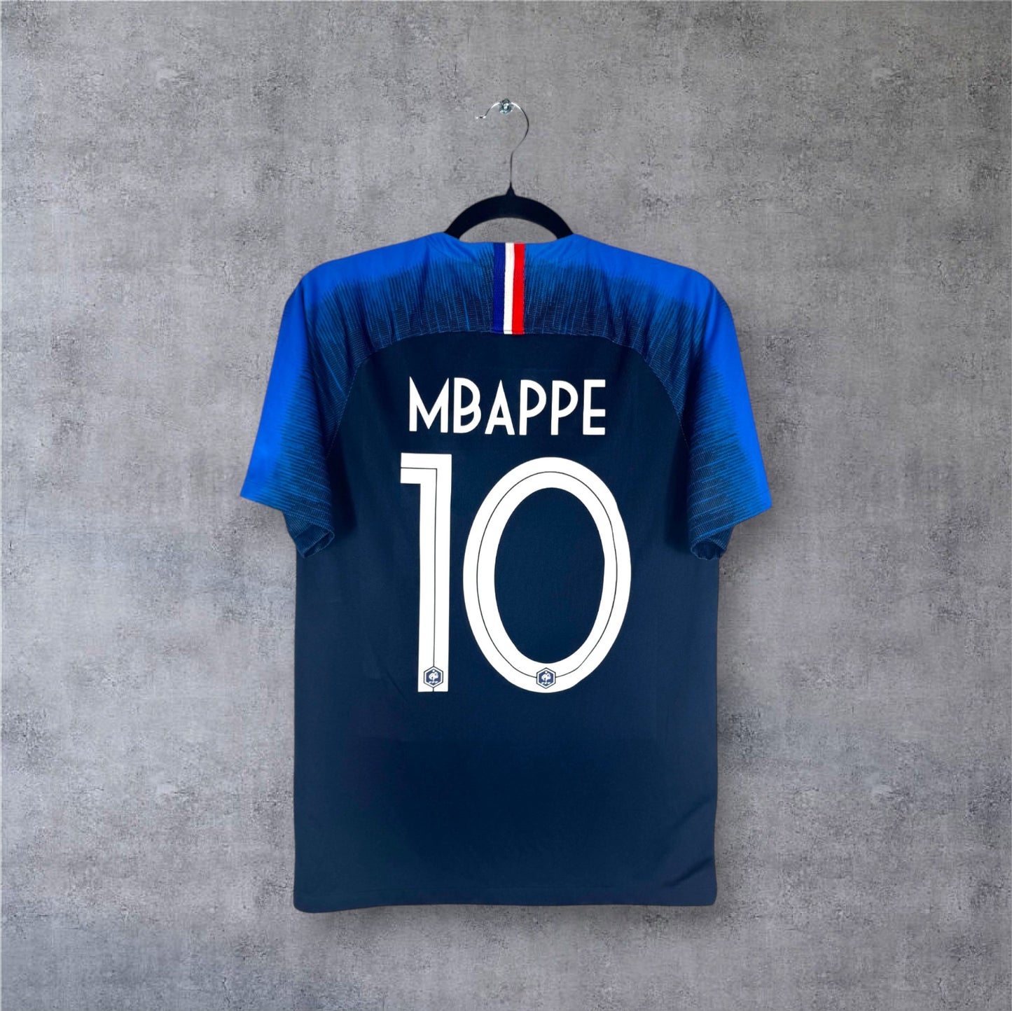 Flocage officiel blanc MBAPPE numéro 10 et détail tricolore au dos du maillot bleu France.