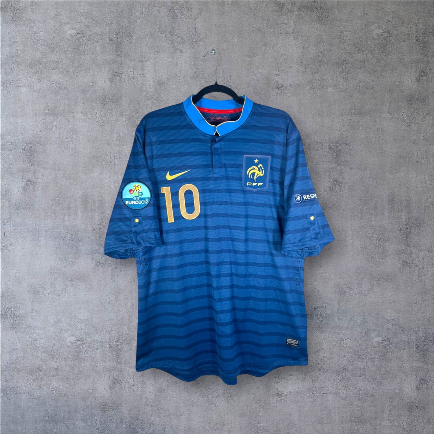 Vue de face du maillot France Domicile 2012 bleu avec rayures ton sur ton, col boutonné et numéro 10 doré.