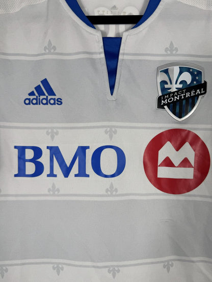 Détail du blason Impact Montréal à la fleur de lys, du logo adidas et du sponsor BMO
