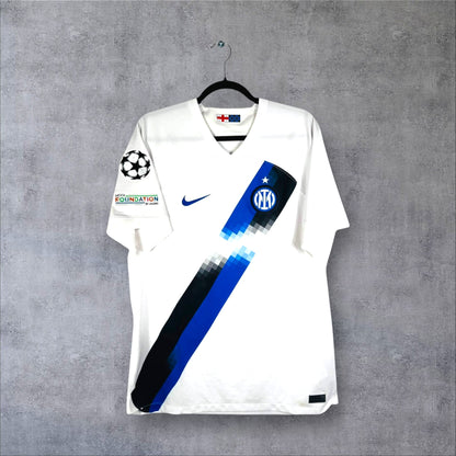 Vue de face du maillot Inter Milan Extérieur 2023/24 blanc avec bande diagonale pixelisée noire et bleue, sans sponsor.