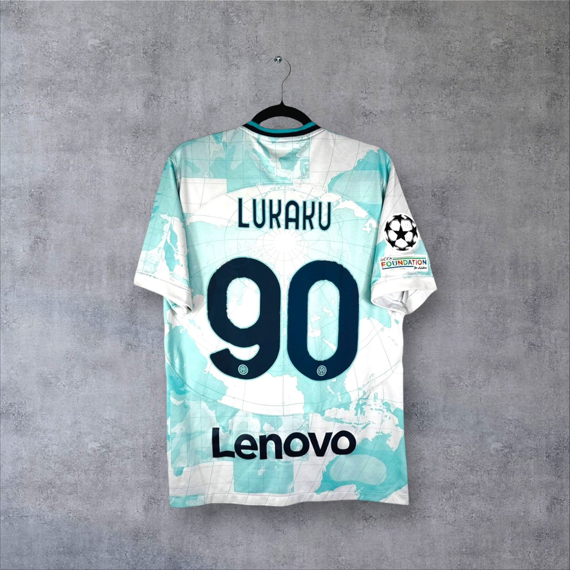 Dos du maillot Inter Milan Extérieur 2023 blanc et bleu avec flocage LUKAKU 90, sponsor Lenovo et patchs Ligue des Champions.