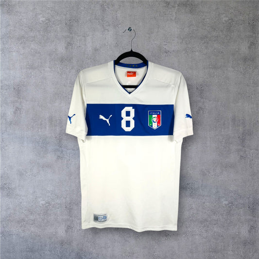 Vue de face du maillot Italie extérieur 2012 blanc avec bande horizontale bleue sur la poitrine.