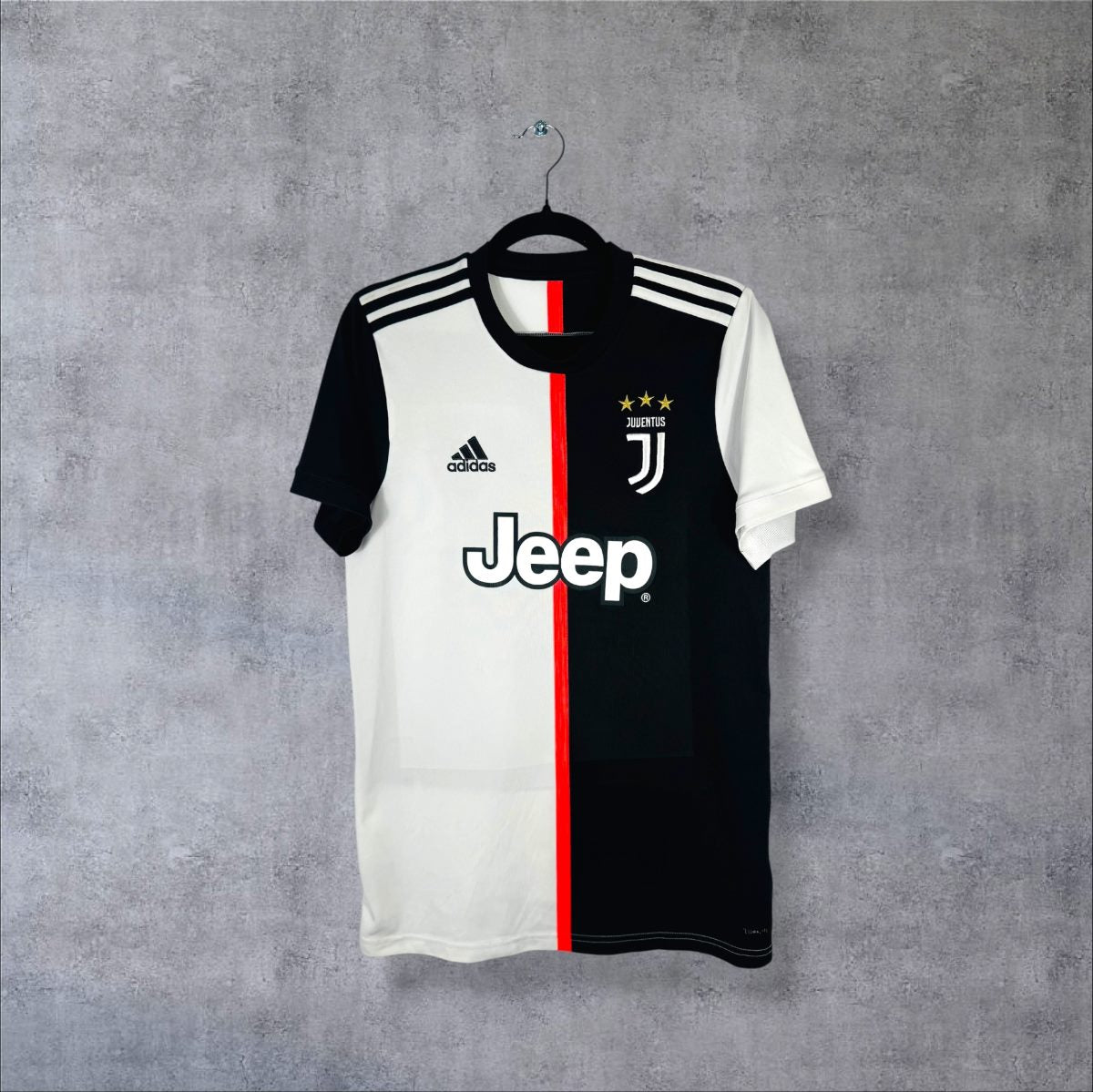 Face du maillot Juventus 2019-2020 domicile mi-blanc mi-noir à bande rouge centrale, sponsor Jeep