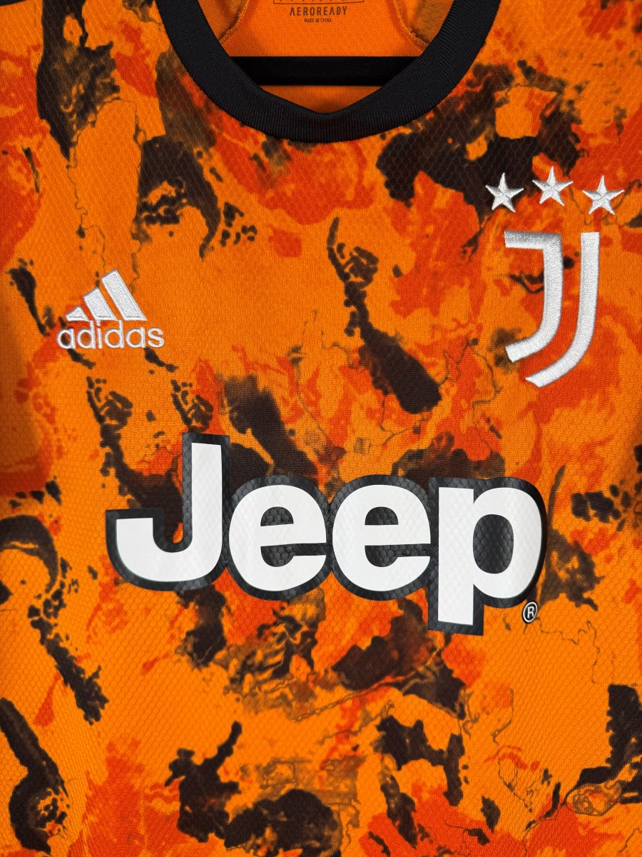 Détail du logo Juventus brodé blanc et des trois étoiles sur le maillot third orange 2020-2021, avec le sponsor Jeep