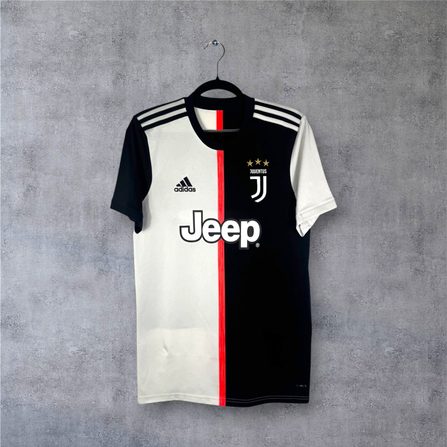 Vue de face du maillot Juventus 2019/20 moitié noir moitié blanc avec ligne rose.