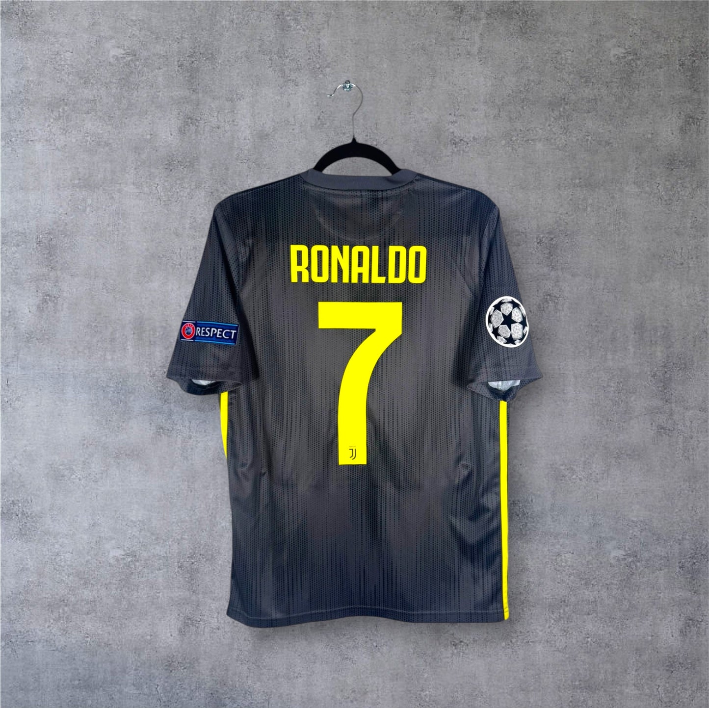 Flocage officiel jaune fluo RONALDO numéro 7 et patchs Ligue des Champions sur maillot gris Juve.