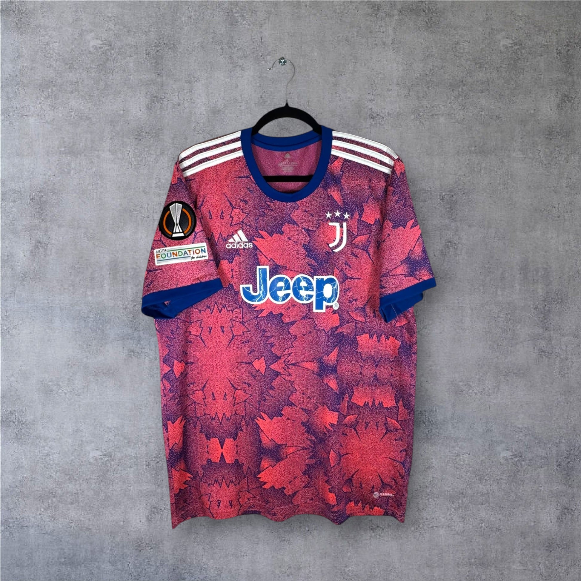 Vue de face du maillot Juventus Third 2022/23 aux motifs graphiques bleus et roses.