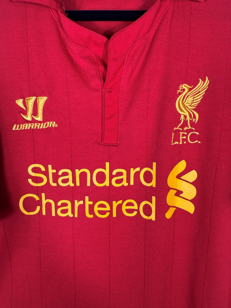 Détail du Liver Bird doré brodé, du logo Warrior et du col boutonné du maillot Liverpool 2012-2013