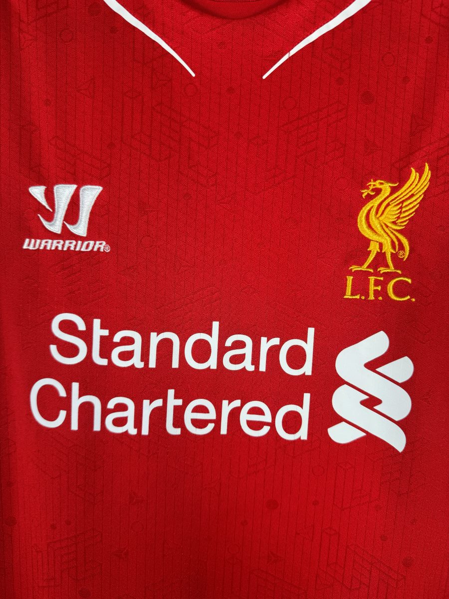 Détail du Liver Bird doré brodé et du logo Warrior sur le maillot Liverpool 2014-2015 domicile