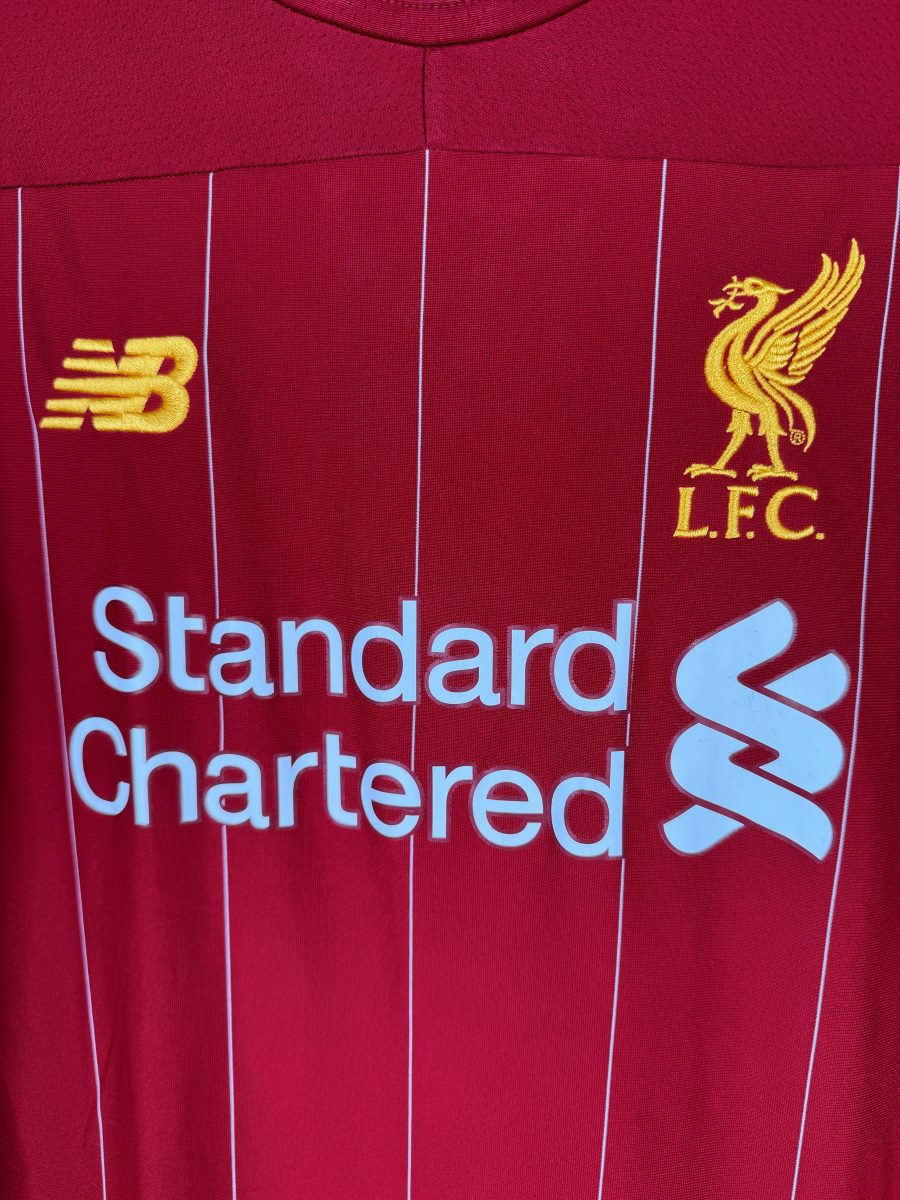 Écusson Liverbird brodé or, logo New Balance et sponsor Standard Chartered, maillot Liverpool 2019-2020