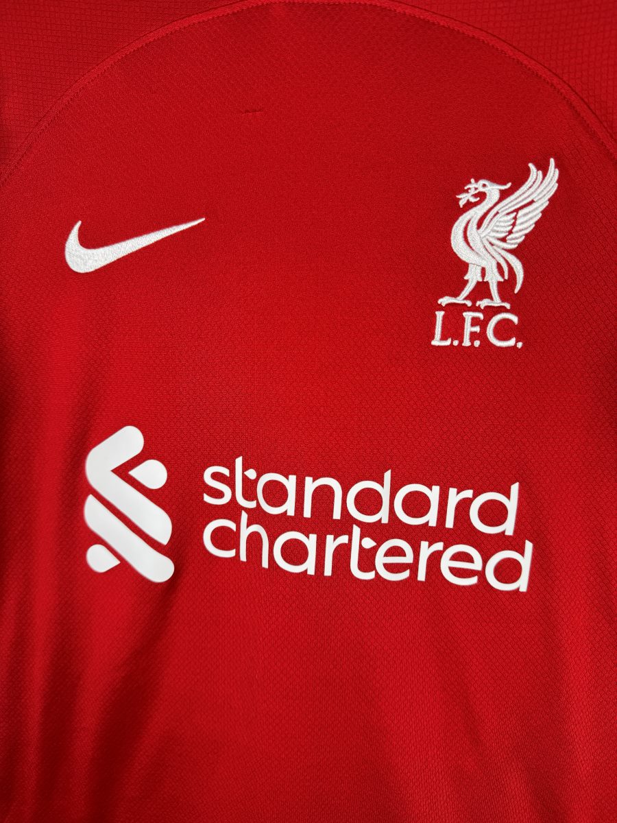 Écusson Liverbird L.F.C. brodé, virgule Nike et sponsor Standard Chartered, maillot domicile Liverpool 2023-2024
