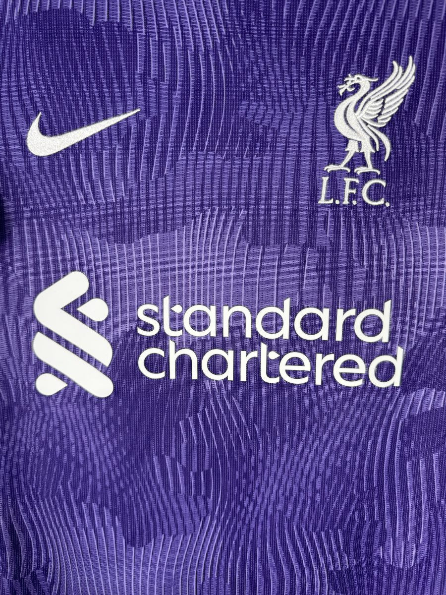 Écusson brodé Liverbird L.F.C. et sponsor Standard Chartered sur le maillot Liverpool 2023-2024 third