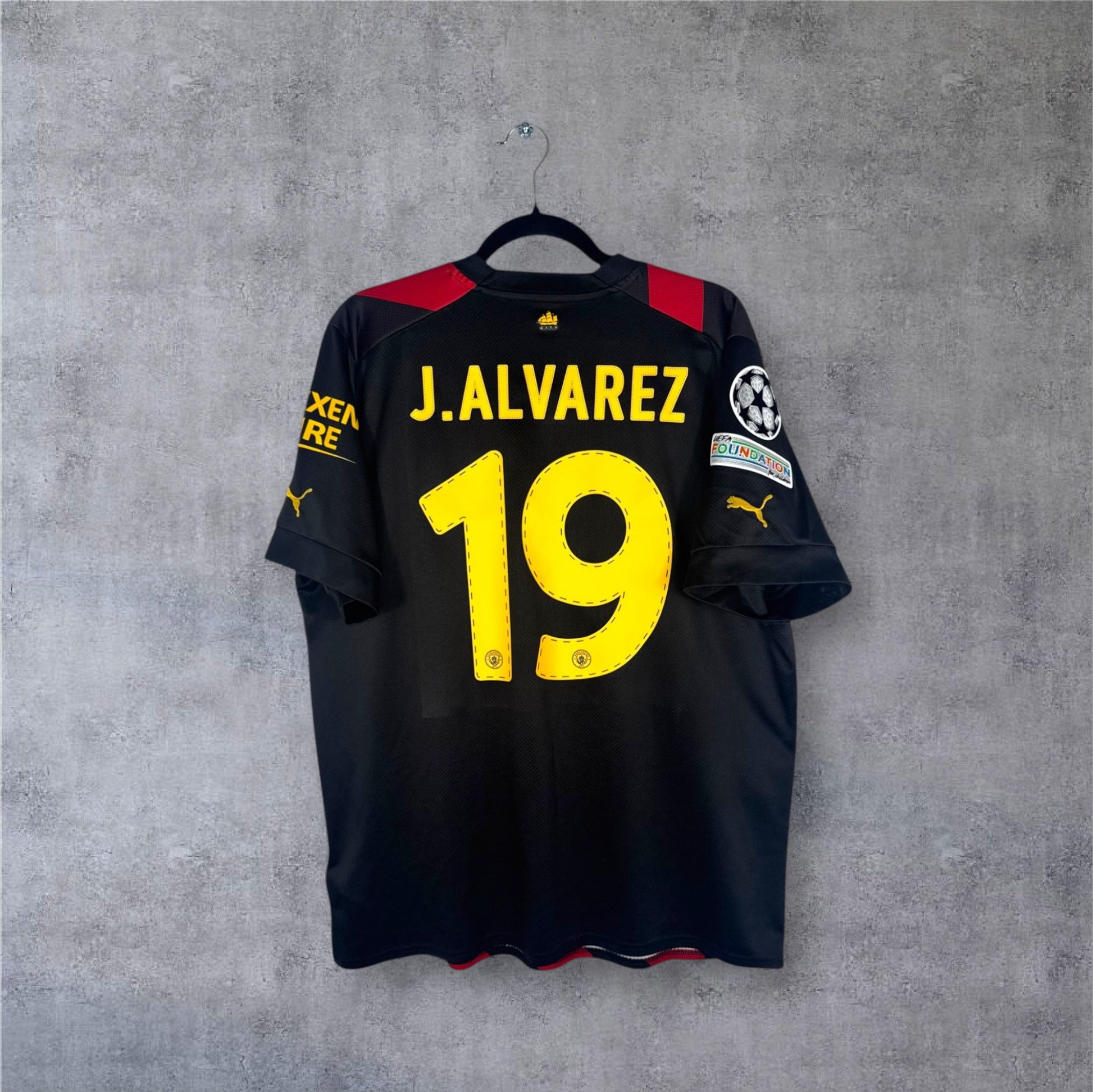 Dos du maillot Man City rouge et noir avec flocage jaune J.ALVAREZ 19 et patchs LDC.