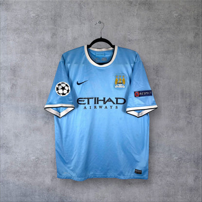Vue de face du maillot Manchester City Domicile 2013/14 bleu ciel avec sponsor Etihad Airways et logo Nike.
