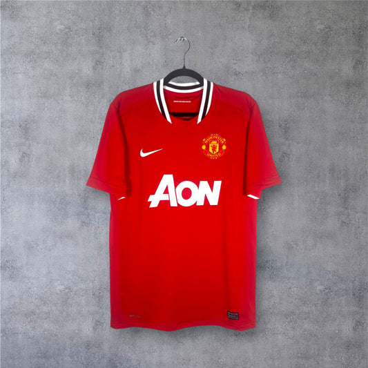 Vue de face du maillot rouge Manchester United 2012 avec col bar-scarf noir et blanc.