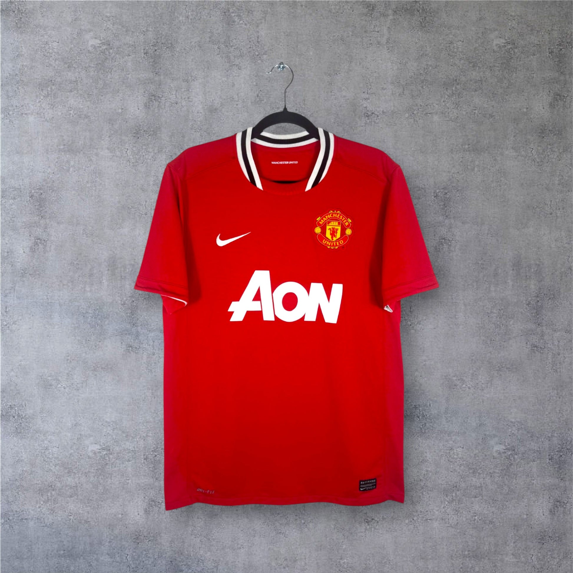 Vue de face du maillot rouge Manchester United 2011/12 avec son col noir et blanc iconique.