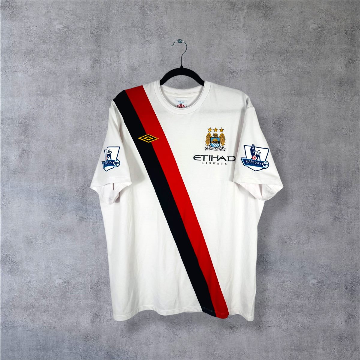Maillot Manchester City third 2009-2010 de face, écharpe rouge et noire, sponsor Etihad