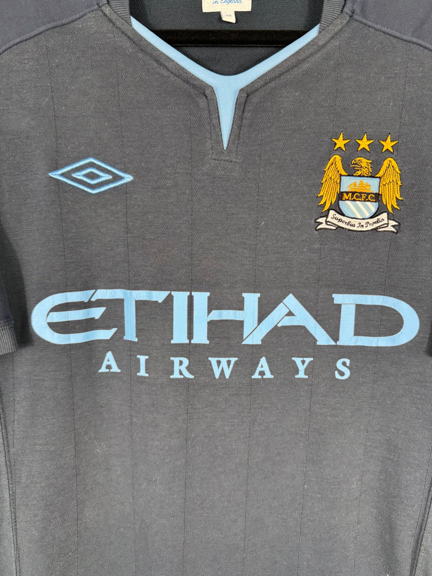 Détail de l'écusson de Manchester City et du logo Umbro
