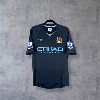 Maillot Manchester City 2010-2011 extérieur bleu nuit de face, sponsor Etihad bleu ciel, col bleu ciel