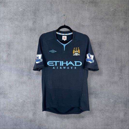 Maillot Manchester City 2010-2011 extérieur bleu nuit de face, sponsor Etihad bleu ciel, col bleu ciel