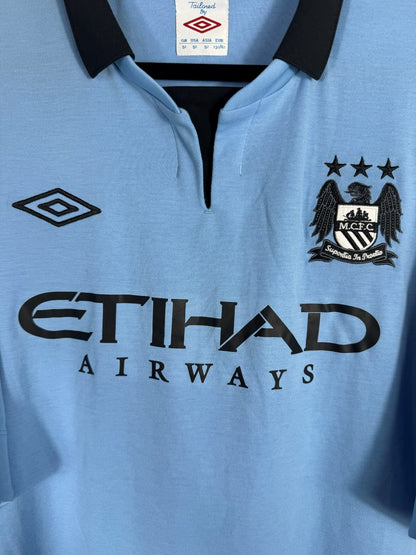 Écusson brodé Manchester City aux trois étoiles, col Tailored by Umbro et sponsor Etihad, maillot domicile 2012-2013