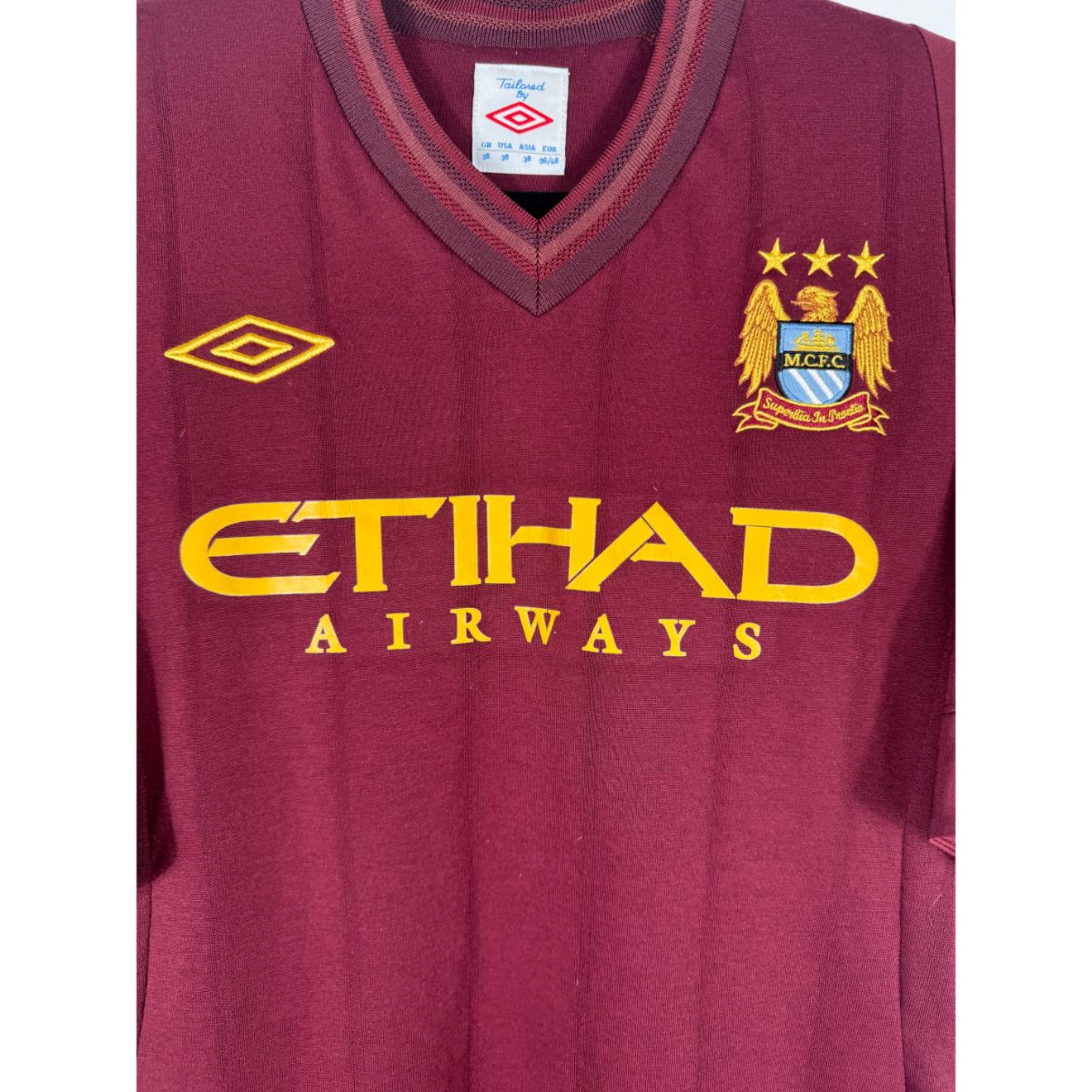 Détail de l'écusson de Manchester City et du logo Umbro