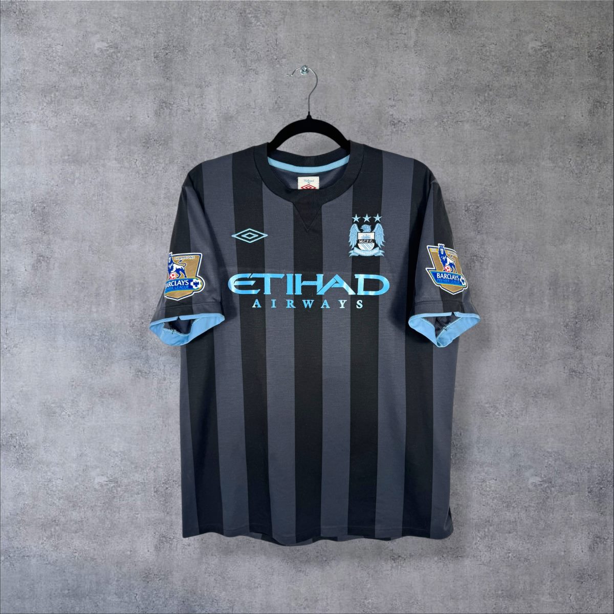 Maillot Manchester City 2012-2013 third de face, rayures noires et anthracite, sponsor Etihad Airways bleu ciel