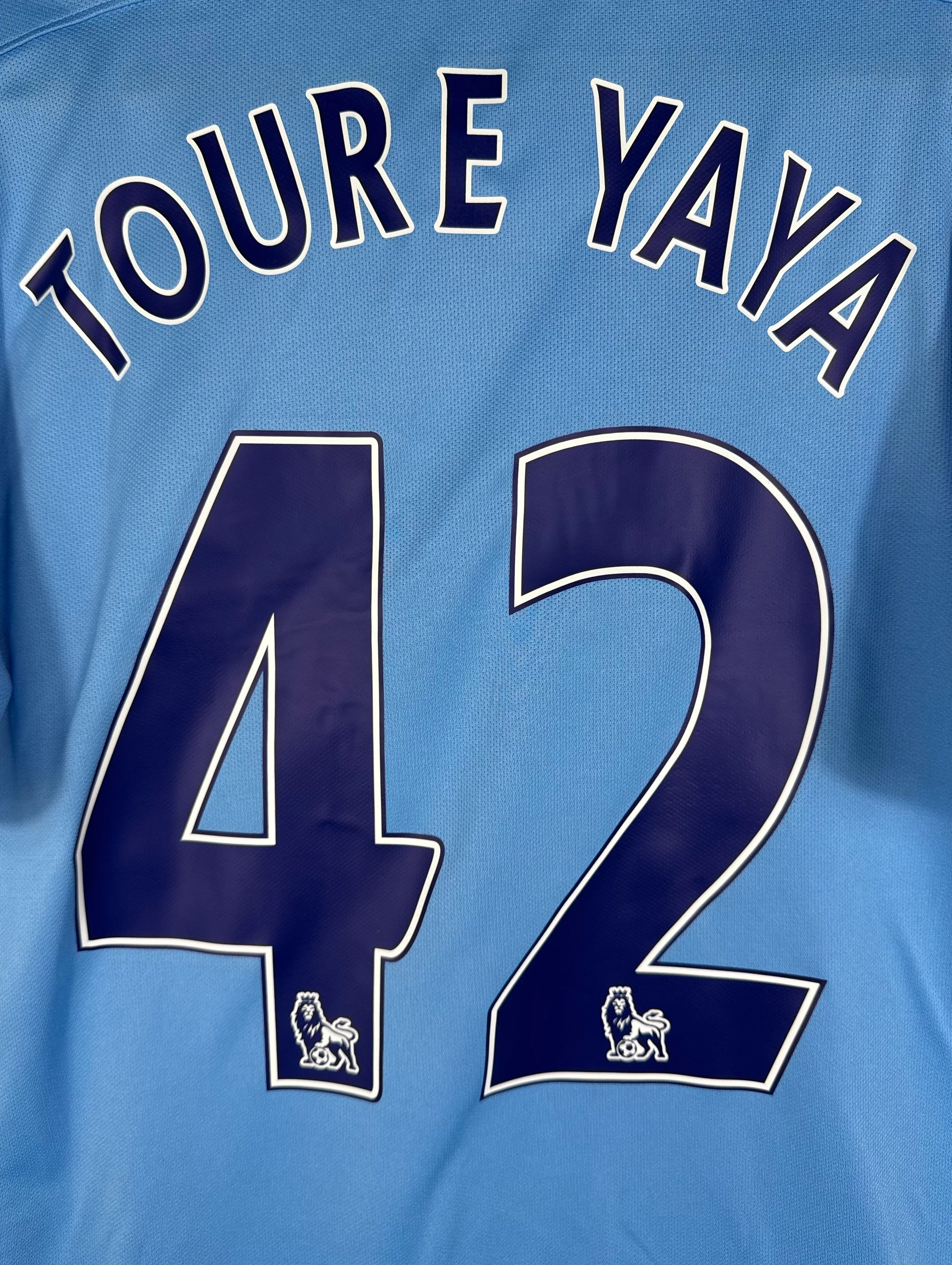 Détail du flocage vintage Premier League avec le lion sur le numéro 42 de Yaya Touré
