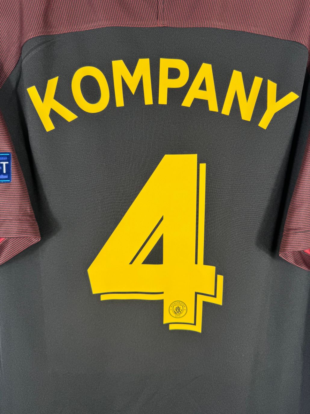 Détail de la typographie du flocage sur le numéro 4 de Vincent Kompany