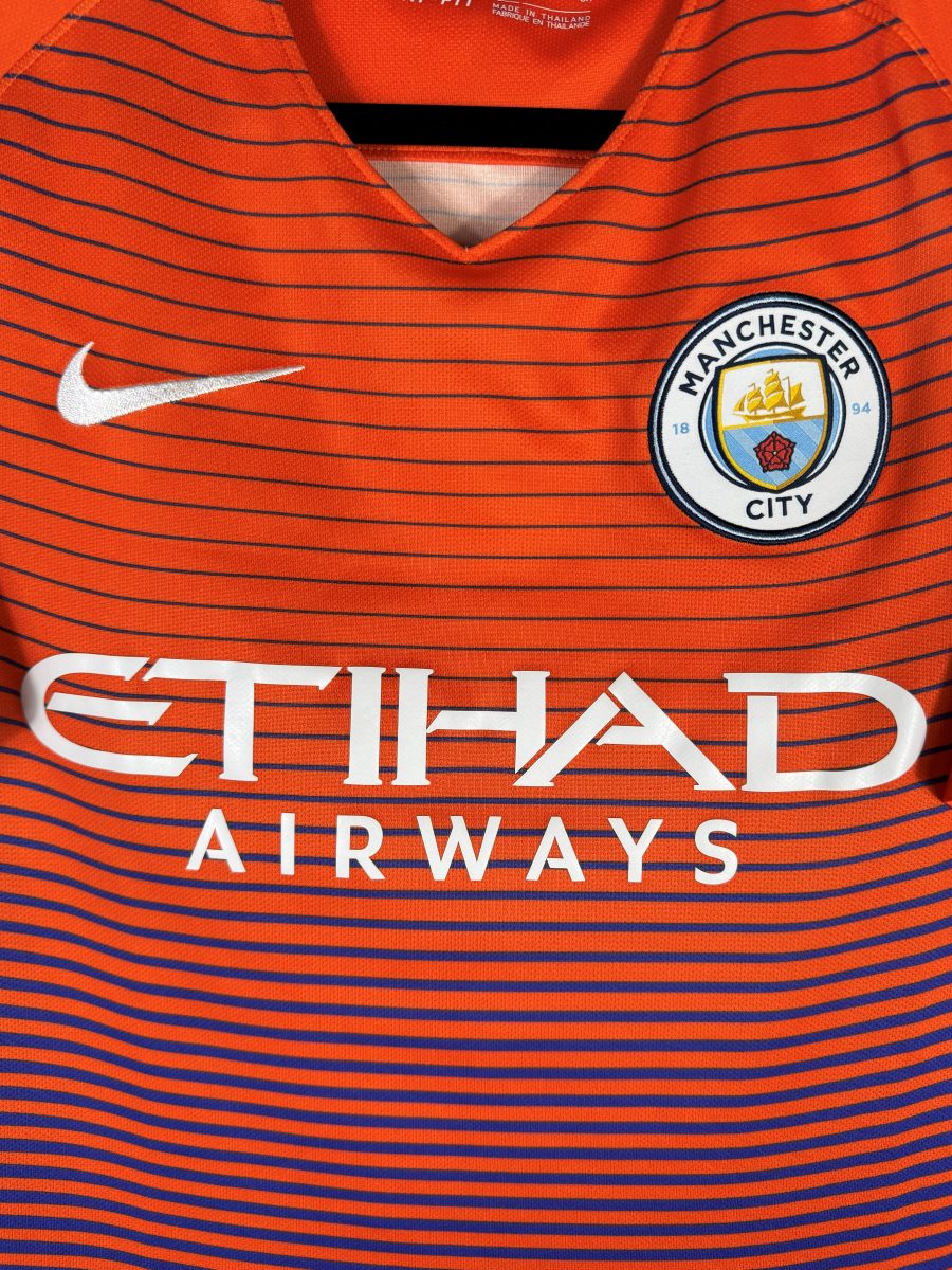 Détail de l'écusson circulaire Manchester City, swoosh Nike et sponsor Etihad Airways sur le third 2016-2017