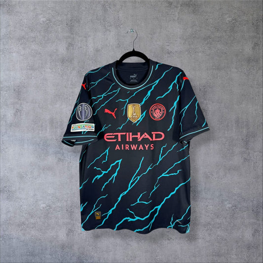 Maillot Manchester City 2023-2024 third Puma face Etihad éclairs turquoise