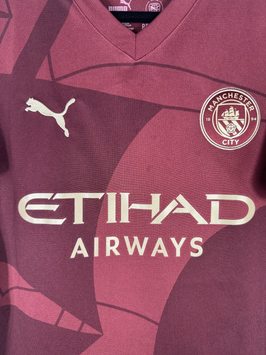 Écusson brodé de Manchester City au navire, sur le maillot third bordeaux 2024-2025