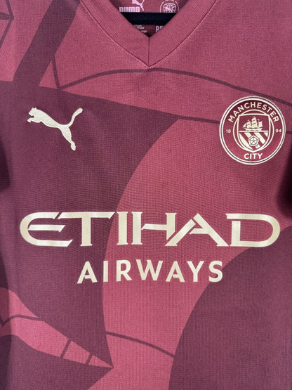 Écusson brodé de Manchester City au navire, sur le maillot third bordeaux 2024-2025