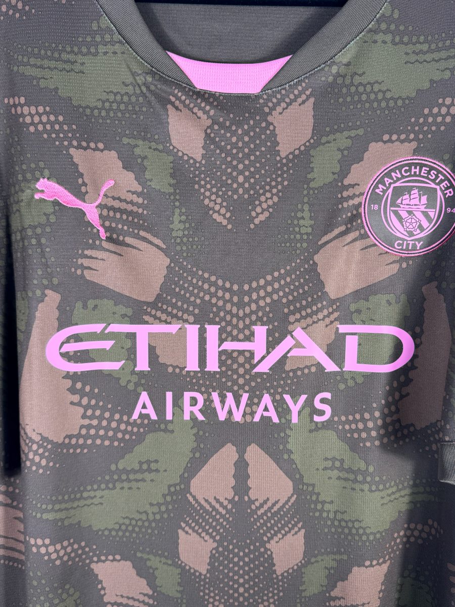 Detail de l ecusson rose de Manchester City et du logo Puma sur le maillot de gardien