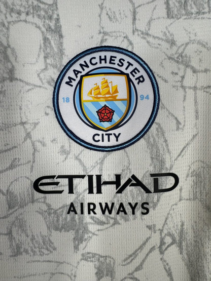 Détail du blason Manchester City brodé, du sponsor Etihad Airways et des illustrations KidSuper