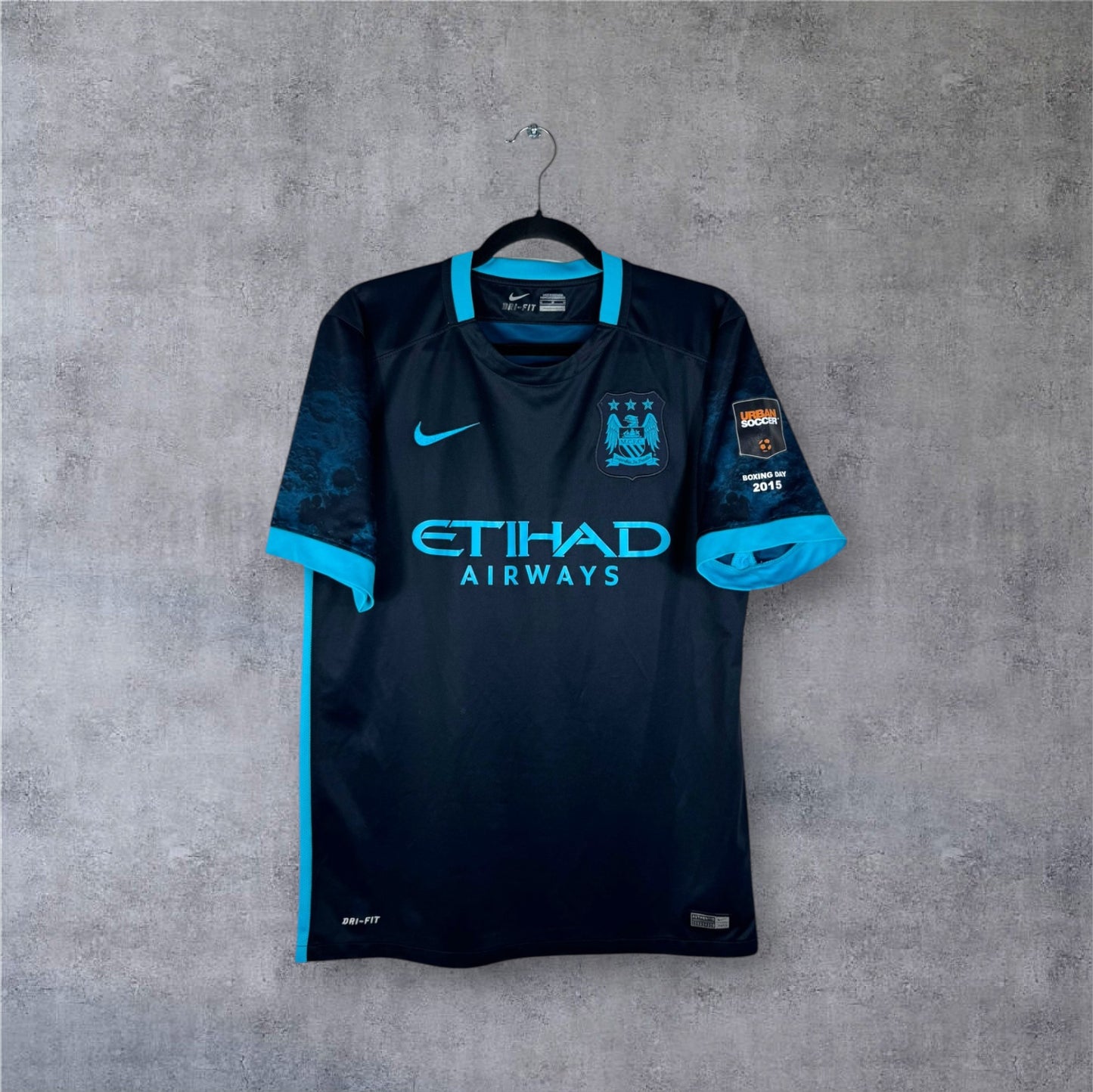Vue de face du maillot Manchester City Extérieur 2015/16 bleu foncé avec manches graphiques.